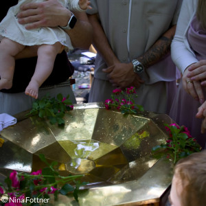 Tauffamilie am Becken mit Babyfüßen
