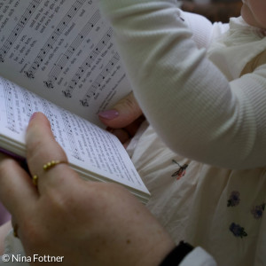 Baby mit Gesangbuch